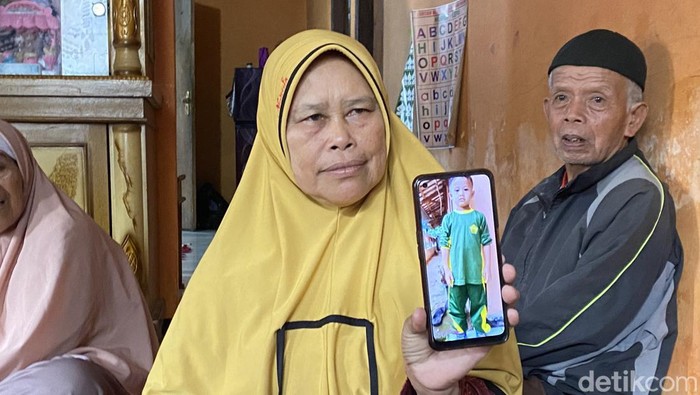 Keluarga menunjukkan foto bocah yang hilang sebelum akhirnya ditemukan meninggal di Sukabumi.