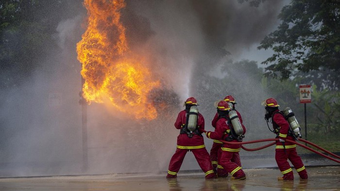 Peserta berupaya memadamkan api nan membakar saluran pipa saat lomba “fire combat” di Pertamina EP Jatibarang Field, Indramayu, Jawa Barat.