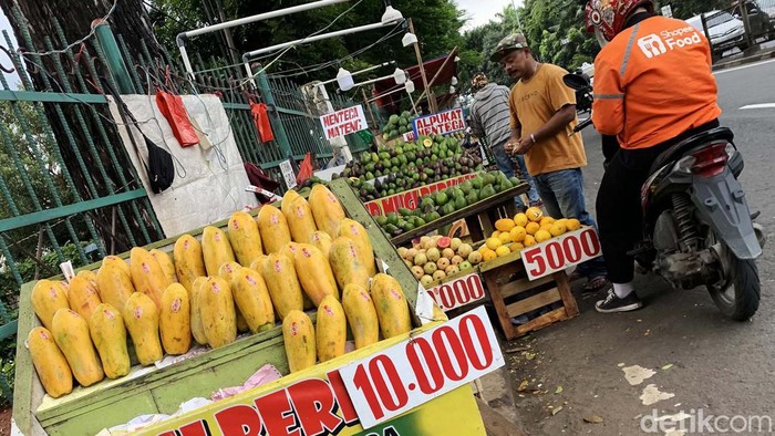 Penjualan Buah Meningkat di Bulan Ramadan Pedagang buah melayani pembeli di kios buah, Jalan Raya Bogor, Jakarta Timur, Senin (18/3/2024).