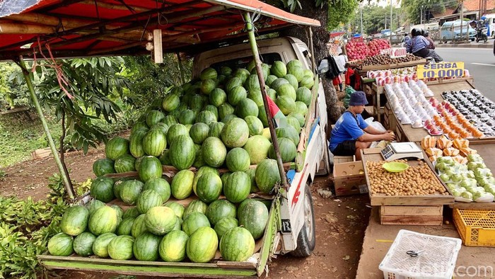 Penjualan Buah Meningkat di Bulan Ramadan Pedagang buah melayani pembeli di kios buah, Jalan Raya Bogor, Jakarta Timur, Senin (18/3/2024).