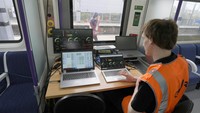Seorang karyawan Great Western Railway memeriksa status baterai kereta uji coba bertenaga baterai pengisian cepat di stasiun kereta West Ealing di London. 
