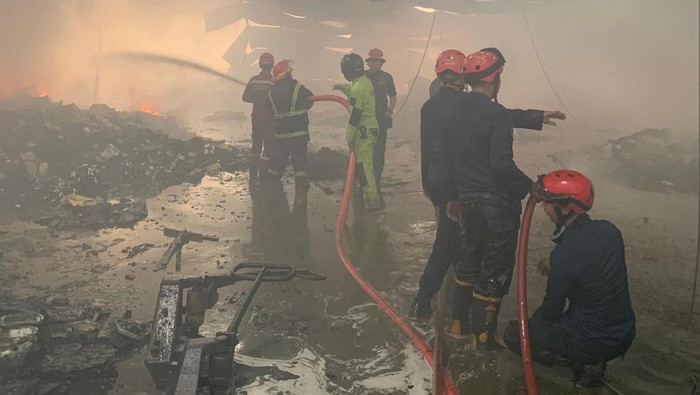 Petugas Damkar Makassar memadamkan api saat salah satu gudang di KIMA Makassar terbakar.