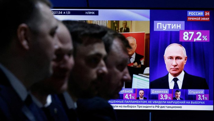 Putin Menang Telak di Pemilu Rusia, Terus Berkuasa hingga 2030 Men sit near a TV broadcasting news on the results of Russian presidential candidate and incumbent President Vladimir Putin, on the final day of the presidential election in Moscow, Russia, March 17, 2024. REUTERS/Maxim Shemetov TPX IMAGES OF THE DAY