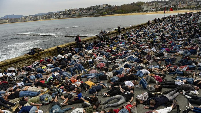 Ratusan Warga Spanyol Berbaring di Tanah Bentuk Protes Genosida di Gaza Demonstrators protest against Israeli attacks on Gaza, along La Concha beach, in San Sebastian, northern Spain, on Sunday, March 17, 2024. (AP Photo/Alvaro Barrientos)