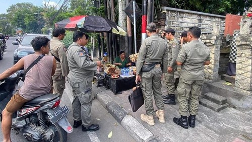 Satpol PP menertibkan pedagang yang menggunakan trotoar di Kota Denpasar.