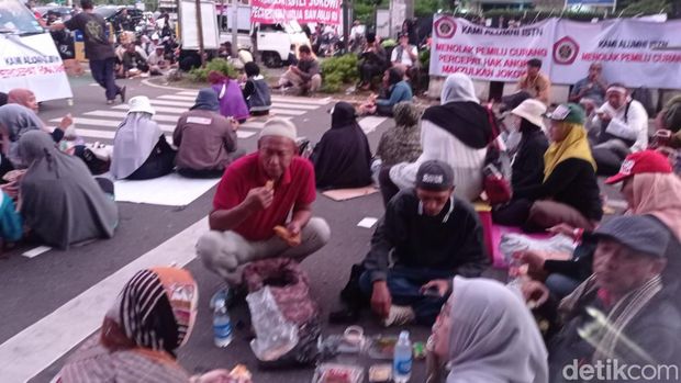 Sejumlah orang yang demonstrasi di dekat gedung KPU RI, Jakarta berbuka puasa bersama. Mereka masing-masing diberi makanan ringan dan air mineral. (Taufiq Syarifudin/detikcom)