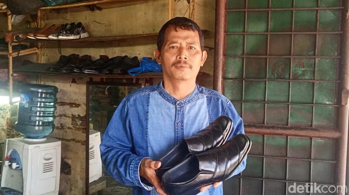 Surianto menunjukkan sepatu hasil produksinya. (Andika Syahputra/detikcom)