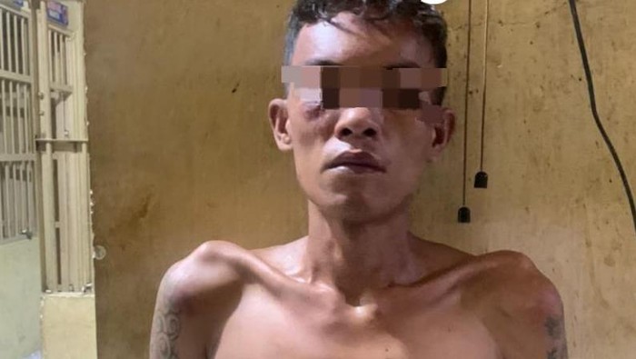 Tersangka saat diamankan di kantor polisi.