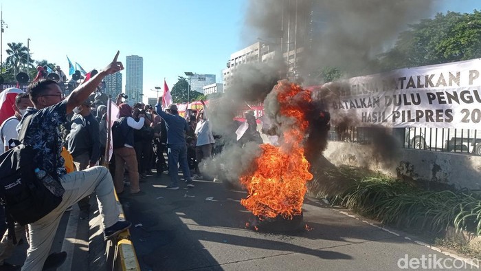 Aksi unjuk rasa di depan gedung DPR RI, Jakarta diwarnai dengan bakar ban. Aksi bakar ban dilakukan sejumlah orang di busway alias jalur Transjakarta (TransJ). (Taufiq S/detikcom)