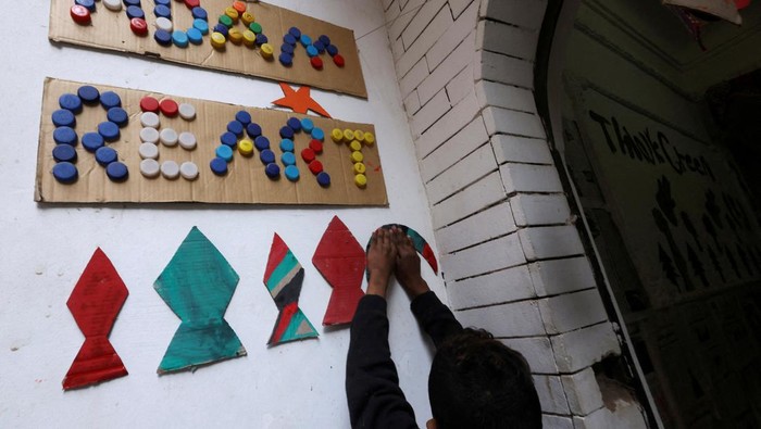 Anak-anak di Mesir Bikin Dekorasi Ramadan Bertema Palestina Nine-year-old Egyptian boy Adam Ragab hangs a piece of cardboard with the colours of the Palestinian flag on the wall at the art studio of Imad Hassan Anwar, founder of the Adam Association for Human Development and Zebala Store project, as children learn to make Ramadan decorations like traditional lanterns and crescents from recycled waste, in an initiative to engrave values and to entrench the Palestinian cause in their minds, in Giza, Egypt, March 15, 2024. REUTERS/Amr Abdallah Dalsh