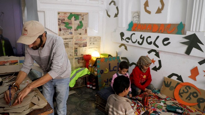 Imad Hassan Anwar, founder of the Adam Association for Human Development and Zebala Store project is seen inside his workshop and art studio, next to children who are learning to make Ramadan decorations like traditional lanterns and crescents from recycled waste, in an initiative to engrave values and to entrench the Palestinian cause in their minds, in Giza, Egypt, March 15, 2024. REUTERS/Amr Abdallah Dalsh