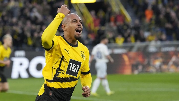 Dortmunds Donyell Malen celebrates after scoring his sides opening goal during the German Bundesliga soccer match between Borussia Dortmund and TSG Hoffenheim in Dortmund, Germany, Sunday, Feb. 25, 2024. (AP Photo/Martin Meissner)