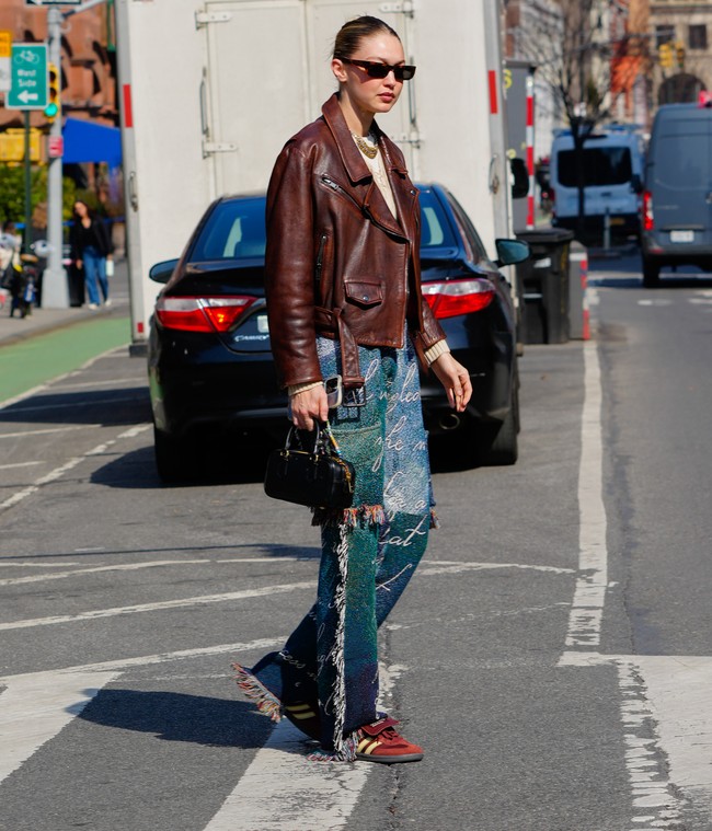 Gigi terlihat stylish dengan jaket kulit coklat. Supermodel 28 tahun itu memadankannya dengan celana jeans dan sepatu Adidas dan tampil semakin keren dengan sunglasses. Foto: GC Images/Gotham via Getty Images