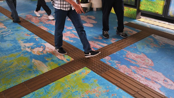 Seorang penumpang turun dari bus Transjakarta di Halte Dukuh Atas, Sudirman, Jakarta, Senin (18/3/2024). Hiasan warna-warni di halte tersebut terinspirasi dari pelukis Prancis Claude Monet dan menjadi spot foto baru untuk penumpang. ANTARA FOTO/ Fakhri Hermansyah/aww.