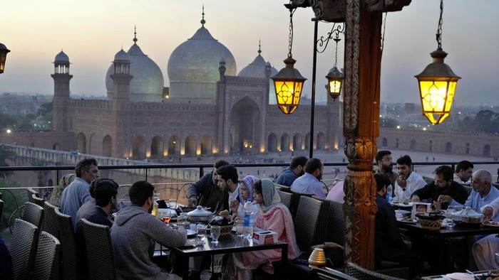 Indahnya Buka Puasa Ditemani Pemandangan Masjid Bersejarah Pakistan People break their fasts during the Muslim's holy fasting month of Ramadan, at a rooftop restaurant near the historical Badshahi mosque, in background, in Lahore, Pakistan, Friday, March 15, 2024. (AP Photo/K.M. Chaudary)