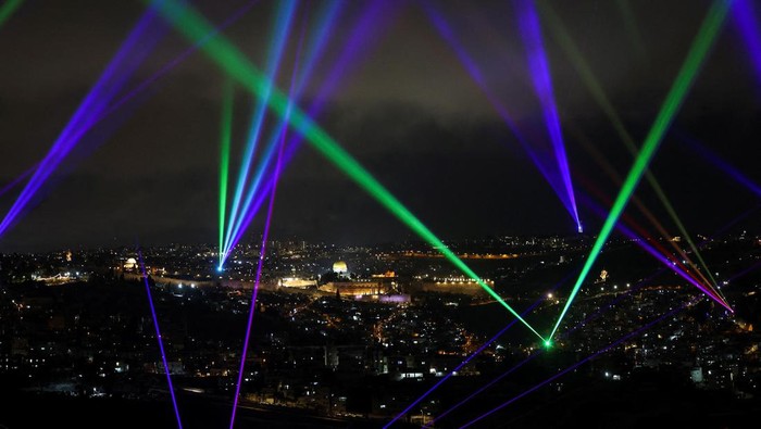 Colourful lasers illuminate the sky above Jerusalem as part of a display longing for peace and harmony, amid the ongoing conflict in Gaza between Israel and Hamas, in Jerusalem March 18, 2024. REUTERS/Ronen Zvulun