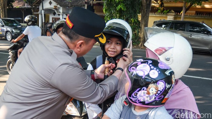 Kapolresta Banyuwangi Kombes Pol Nanang Haryono saat membagikan helm kepada siswa di SDN 1 Mojopanggung, Kecamatan Giri.