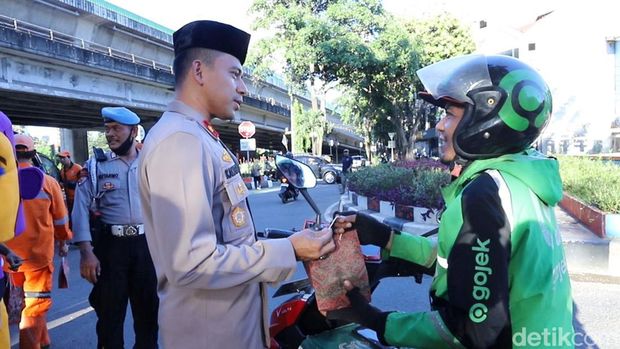 Kapolsek Mampang Prapatan Kompol David Y Kanitero membagikan takjil sambil memberi pesan kamtibmas kepada petugas kebersihan dan masyarakat. (dok Ist)