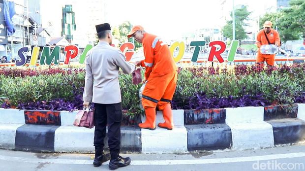 Kapolsek Mampang Prapatan Kompol David Y Kanitero membagikan takjil sambil memberi pesan kamtibmas kepada petugas kebersihan dan masyarakat. (dok Ist)
