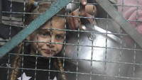 Sebuah dapur umum di kamp pengungsi Jabaliy, Gaza selatan menyiapkan panci besar berisi makanan untuk dibagikan, sementara anak-anak menunggu dengan piring kosong untuk diisi.  