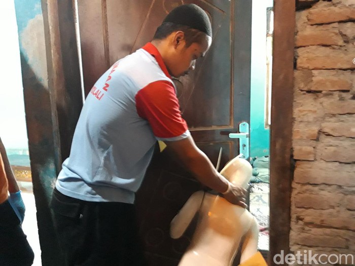 Tersangka Muhammad Rosyid memperagakan saat menganiaya anak tirinya dalam reka ulang yang digelar di rumahnya, Selasa.(19/3/2024)