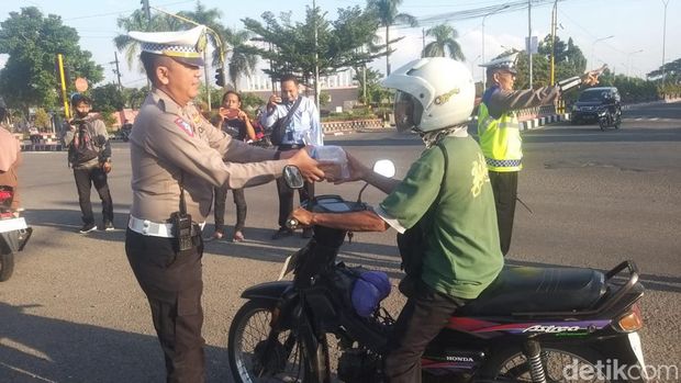 Polisi Ngawi sosialisasi keselamatan mudik saat bagi-bagi takjil di pertigaan Banyakan, Ngawi.