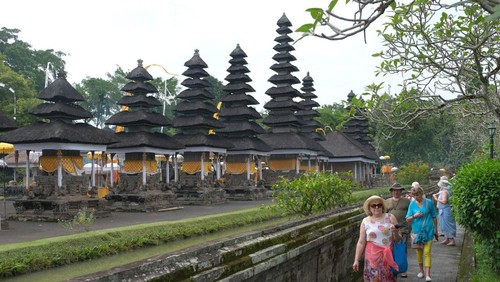 Wisatawan mancanegara menikmati keindahan pura saat mengunjungi objek wisata Pura Taman Ayun, Badung, Bali, Senin (18/3/2024). Pulau Bali kembali dinobatkan sebagai salah satu destinasi wisata terbaik di dunia dengan memperoleh predikat The Best Island dalam DestinAsian Readers’ Choice Awards. ANTARA FOTO/Nyoman Hendra Wibowo/aww.