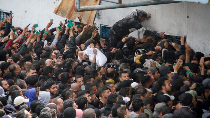 Palestinians gather to receive aid outside an UNRWA warehouse as Gaza residents face crisis levels of hunger, amid the ongoing conflict between Israel and Hamas, in Gaza City March 18, 2024. REUTERS/Mahmoud Issa