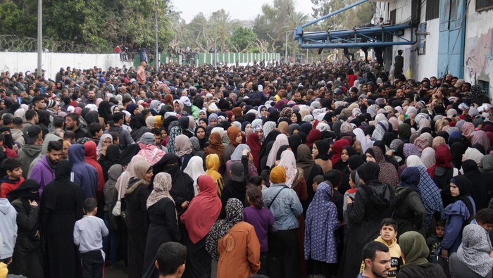 Palestinians gather to receive aid outside an UNRWA warehouse as Gaza residents face crisis levels of hunger, amid the ongoing conflict between Israel and Hamas, in Gaza City March 18, 2024. REUTERS/Mahmoud Issa