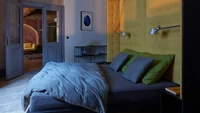 Tempat tidurnya dilengkapi dengan sandaran kepala besar yang terhubung dengan lemari di belakangnya. Tempat tidur itu ditempatkan di tengah kamar dan dibuat miring untuk memberikan pemandangan terbaik dari jendela dan lukisan langit-langit. Foto: BoysPlayNice via Dezeen