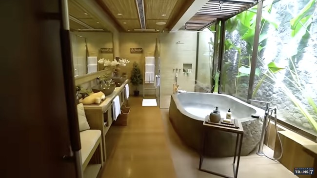 Beginilah penampakan kamar mandi utama Meiline Tenardi yang luasnya hampir menyamai kamar tidur sendiri. Nuansa Bali yang lekat dengan alam makin terasa di sini berkat kehadiran bathtub yang terbuat dari batu. Ini batu asli yang dibentuk jadi bathtub, kata Meiline. (Foto: YouTube/Trans7 Official)