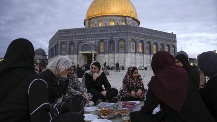Palestinian Muslims break their fast during the Muslim holy month of Ramadan outside the Dome of Rock at the Al-Aqsa Mosque compound in the Old City of Jerusalem, Saturday, March 16, 2024. (AP Photo/Mahmoud Illean)