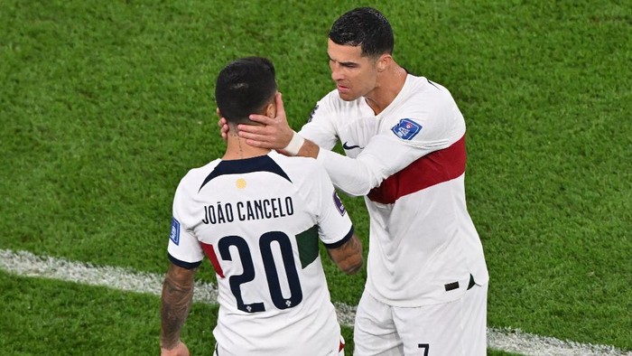 Portugals forward #07 Cristiano Ronaldo and Portugals defender #20 Joao Cancelo cheer themselves up before getting onto the pitch on the second-half of the Qatar 2022 World Cup quarter-final football match between Morocco and Portugal at the Al-Thumama Stadium in Doha on December 10, 2022. (Photo by NELSON ALMEIDA / AFP)
