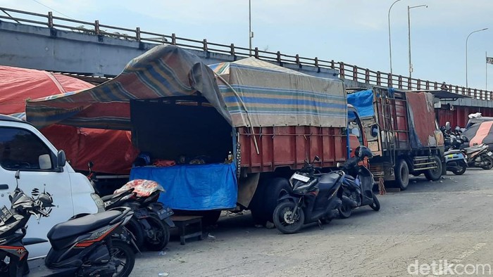 Truk-truk berjejer di jembatan Tanggulangin jadi tempat pengungsia warga Demak yang terkena banjir, Selasa (19/3/2024).