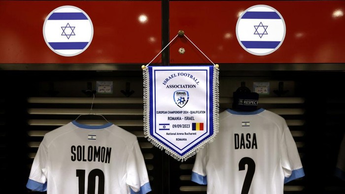 BUCHAREST, ROMANIA - SEPTEMBER 09: The match pennant is seen alongside the shirts of Manor Solomon and Eli Dasa inside the Israel dressing room prior to the UEFA EURO 2024 European qualifier match between Romania and Israel at National Arena on September 09, 2023 in Bucharest, Romania. (Photo by Francesco Scaccianoce - UEFA/UEFA via Getty Images )