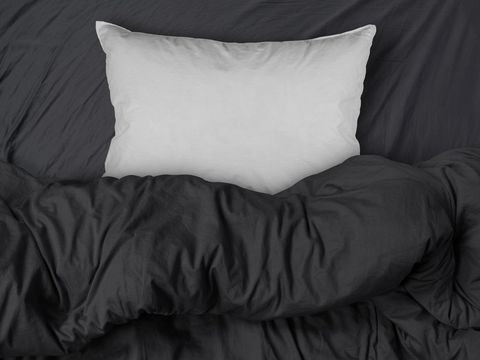 studio shot of black themed bedding sheets and white pillow