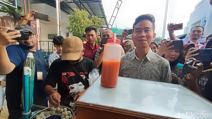 Gibran Rakabuming membeli cilok dagangan penjual yang mengenakan kaus bergambar Ganjar Pranowo di depan Masjid Sheikh Zayed Solo, Rabu (20/3/2024).