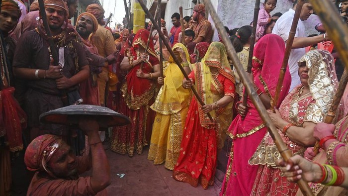 Villagers from Barsana and Nandgaon smeared with colors play Lathmar Holi at Nandagram temple in Nandgoan village, 115 kilometers (70 miles) south of New Delhi, India, Tuesday, March 19, 2024. Women from Nandgaon, the birthplace of Hindu God Krishna, beat the men from Barsana, the legendary birthplace of Radha, the consort of Krishna, with wooden sticks in response to their efforts to put color on them. The same act is then replicated in Barsana between the women of that village and the men of Nandgaon as they observe the Lathmar Holi festival, a celebration of love and friendship. (AP Photo/Kabir Jhangiani)