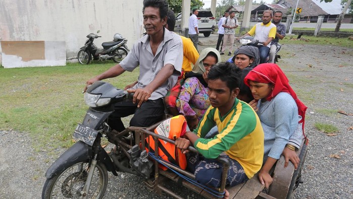 Lagi-lagi Pengungsi Rohingya Mendarat di Aceh Barat Warga membonceng pengungsi Rohingya dengan becak motor untuk ditempatkan di kantor Kecamatan Samatiga, Aceh Barat, Aceh, Rabu (20/3/2024). Sebanyak enam orang pengungsi Rohingya yang terdiri dua laki-laki dan empat perempuan tersebut diselamatkan nelayan Desa Kuala Bubon setelah kapal mereka terbalik sekitar 15 mil di perairan Samudra Hindia, sedangkan puluhan pengungsi Rohingya lainnya masih berada di perairan. ANTARA FOTO/Syifa Yulinnas/nym.