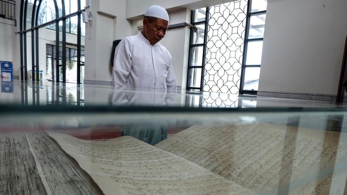 Seorang jamaah melihat Al Quran peninggalan pemerintahan Paku Buwono X yang dipajang di Masjid Fatimah Solo, Jawa Tengah, Rabu (20/3/2024). Al Quran yang ditulis di atas kulit unta tersebut berukuran besar dengan panjang 1,75 meter, lebar 1,15 meter dan berat 40kg sekaligus menjadi ikon Masjid Raya Fatimah Solo dan daya tarik bagi jamaah. ANTARAFOTO/Maulana Surya/nym.