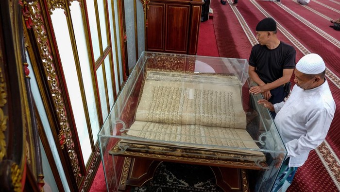 Seorang jamaah melihat Al Quran peninggalan pemerintahan Paku Buwono X yang dipajang di Masjid Fatimah Solo, Jawa Tengah, Rabu (20/3/2024). Al Quran yang ditulis di atas kulit unta tersebut berukuran besar dengan panjang 1,75 meter, lebar 1,15 meter dan berat 40kg sekaligus menjadi ikon Masjid Raya Fatimah Solo dan daya tarik bagi jamaah. ANTARAFOTO/Maulana Surya/nym.
