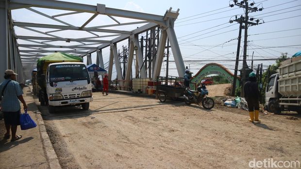 Petugas pekerja penanggulangan tanggul Sungai Wulan Demak yang jebol dari Jembatan Tanggulangin, Rabu (20/3/2024).