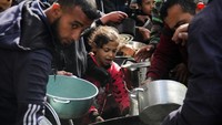 Tampak seorang anak mengantre makanan di tengah-tengah orang dewasa.  