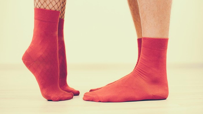 Low Section Of Man And Woman Legs Dating in Red Socks