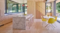 Kalau dapur dan ruang makan di rumah kamu dibuat menyatu, kamu bisa menggunakan warna kuning pada kursi makan seperti ini. Foto: MORTEN SMIDT FOR SARAH JEFFERYS ARCHITECTURE + INTERIORS via Real Simple
