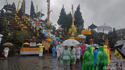 Hujan mengguyur pemedek di Pura Agung Besakih, Kamis (21/3/2024). (Foto: I Wayan Selamat Juniasa/detikBali)
