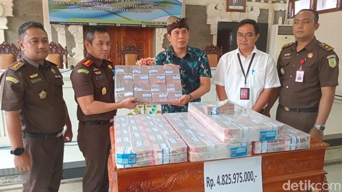 Kajari Denpasar Agus Setiadi menyerahkan uang hasil lelang aset sitaan kasus korupsi duit parkir, Kamis (21/2/2024) (Aryo Mahendro/detikBali)