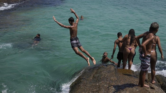 'Neraka Bocor' di Brasil, Suhu Capai 62 Derajat Celcius People cool off in the waters of Arpoador beach amid a heat wave, in Rio de Janeiro, Brazil, Wednesday, March 20, 2024. (AP Photo/Silvia Izquierdo)