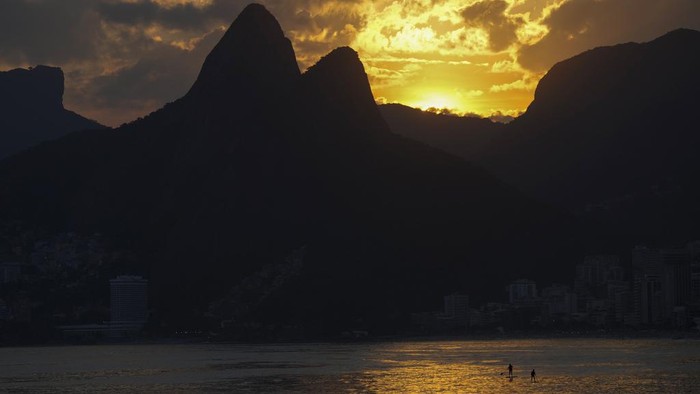 People cool off in the waters of Arpoador beach amid a heat wave, in Rio de Janeiro, Brazil, Wednesday, March 20, 2024. (AP Photo/Silvia Izquierdo)