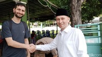 Mr. Mucahit Demir dari iHH (kiri) dan Mr. Mahmoud dari Satu Tangan Kebaikan (kanan) sedang berjabat tangan saat baru sampai Masjid Riyadhus Sholihin. Foto: Fayyas/detikcom